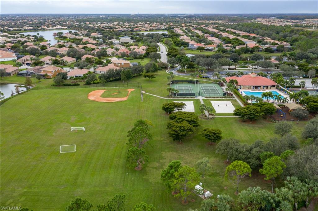 Expansive recreational grounds featuring a regulation baseball diamond with infield, multiple soccer fields, manicured lawn, and mature tree landscaping