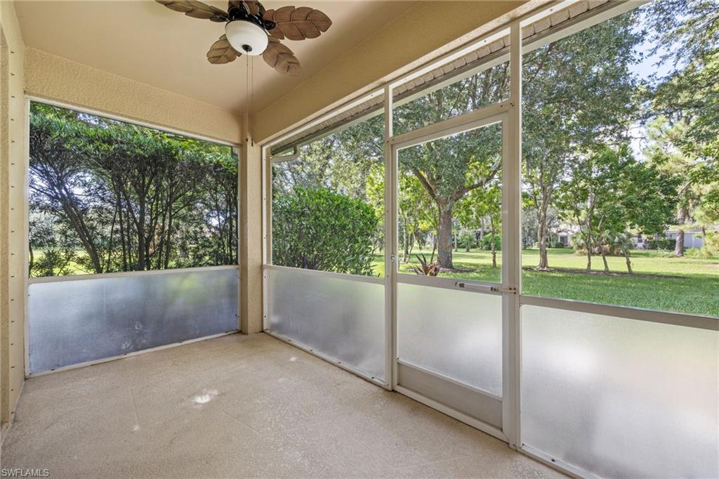 Enclosed screened porch with expansive windows framing mature landscaping and open grounds