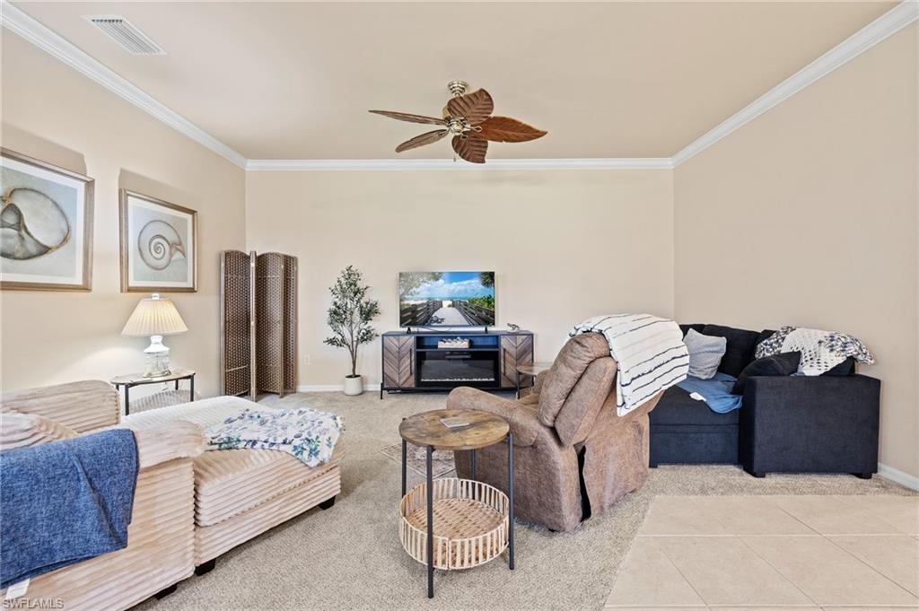 Crown molding, carpet flooring, ceiling fan, and a tiled entry