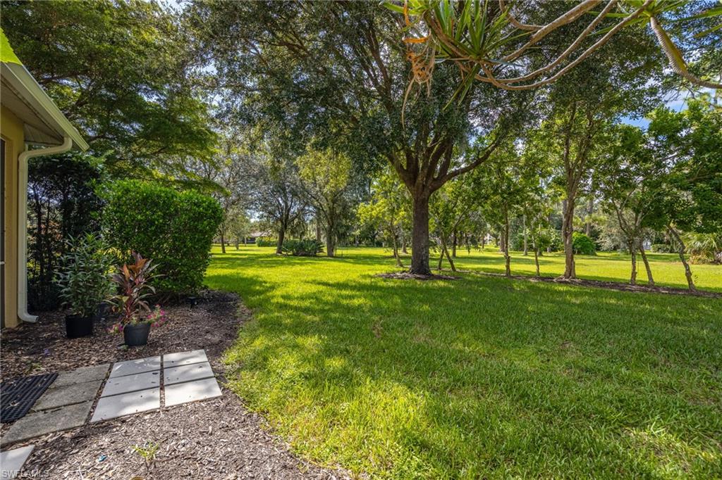 Expansive grounds featuring mature shade trees, lush manicured lawn, and established landscape plantings
