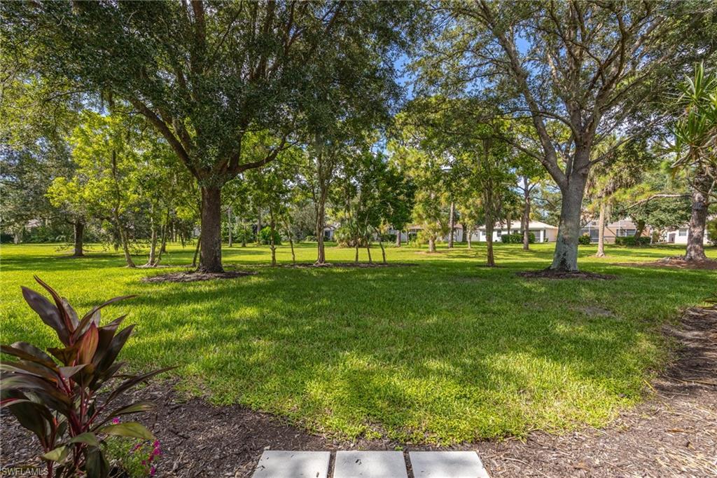 Expansive manicured lawn with mature shade trees throughout the property, providing ample outdoor space and natural canopy coverage