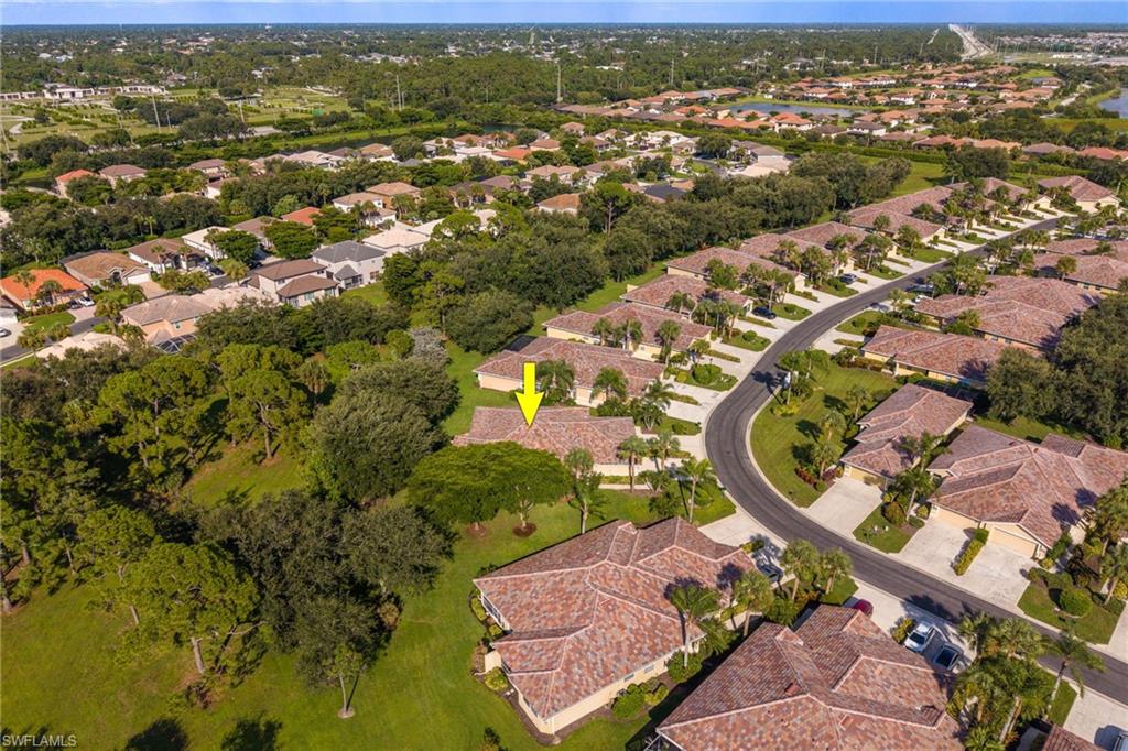 Aerial view showcasing this residence nestled within a mature tree-lined community