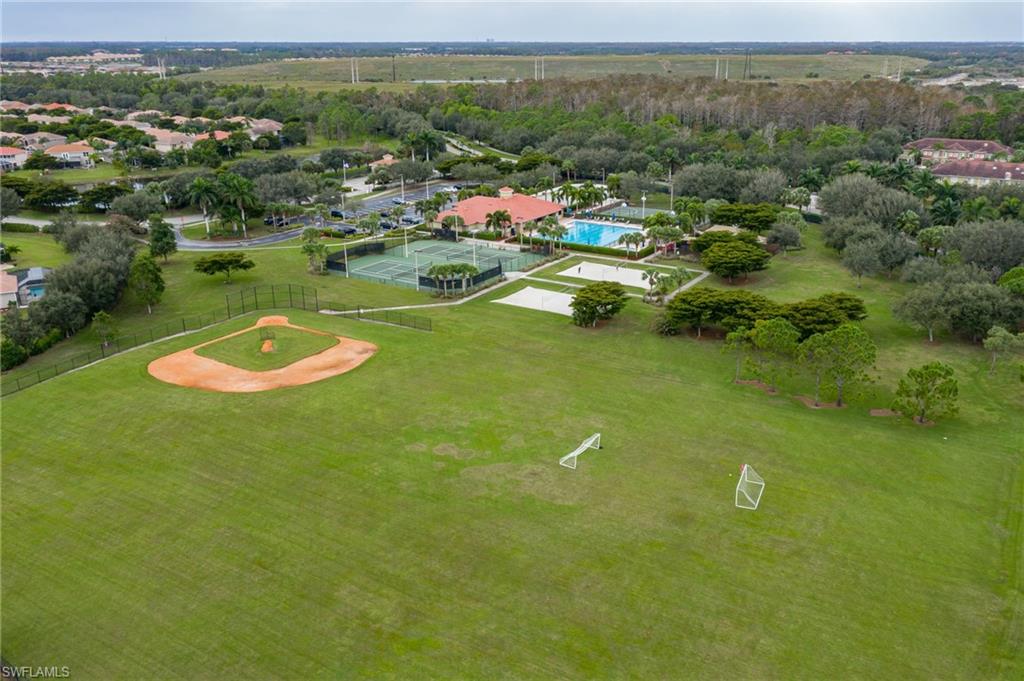 Spacious green areas featuring a baseball diamond, two soccer goals, tennis courts, sand volleyball courts, and a swimming pool
