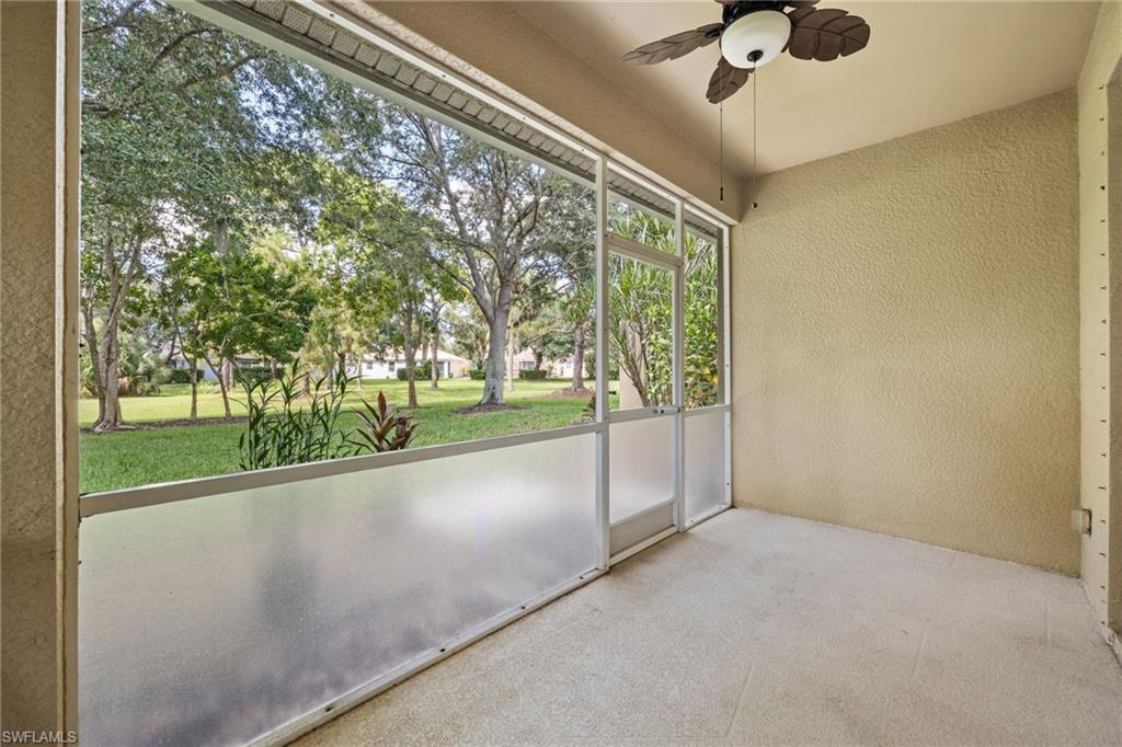 Bright sunroom with expansive sliding glass doors framing mature landscaping and open grounds