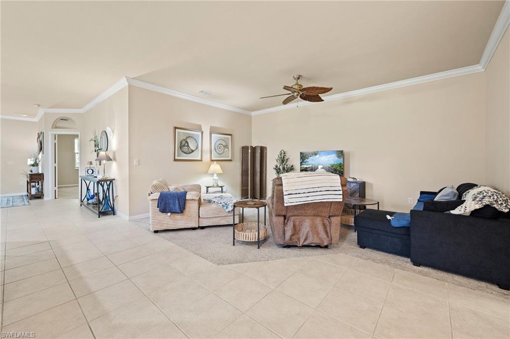 Spacious primary suite with tile flooring throughout, ceiling fan, and abundant natural light
