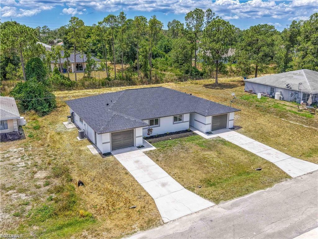 Modern single-story residence featuring a dark asphalt shingle roof, clean concrete driveway, and two-car garage