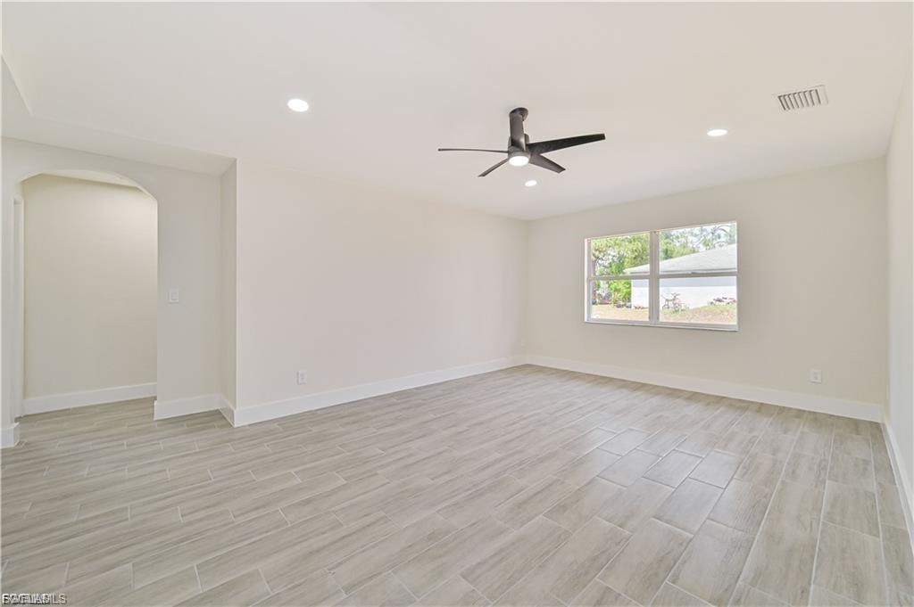 Spacious room featuring light-toned tile flooring, recessed lighting, and a contemporary ceiling fan