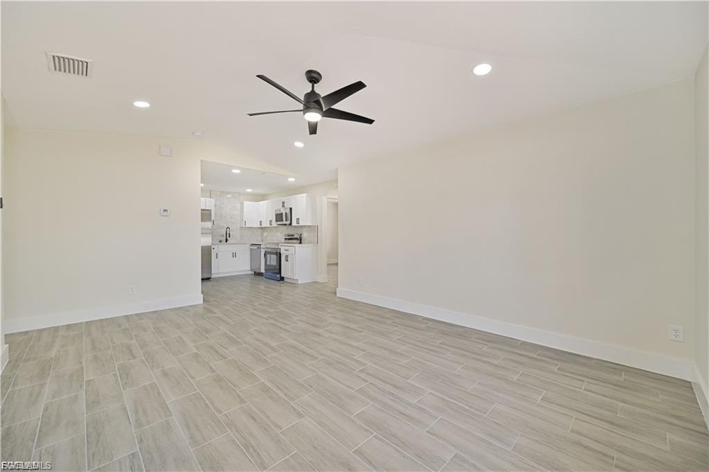 Open-concept living space featuring plank-style wood-finish flooring, recessed ceiling lighting, and a ceiling fan with integrated light fixture