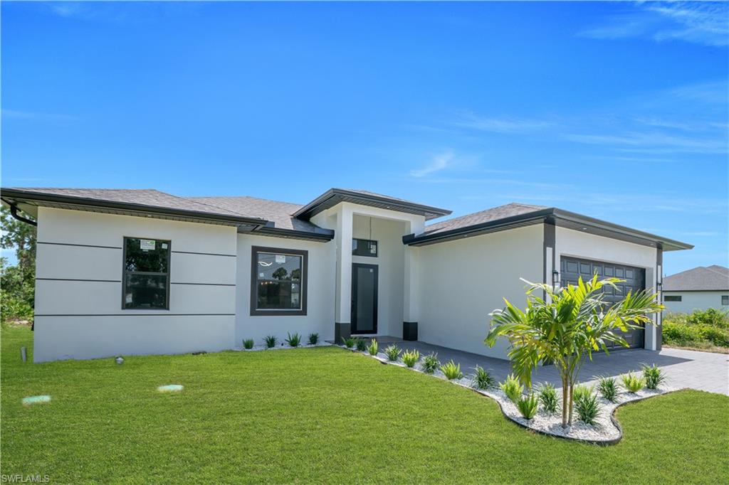 Contemporary stucco exterior with architectural banding, integrated garage, covered entry, and landscaping with a palm tree