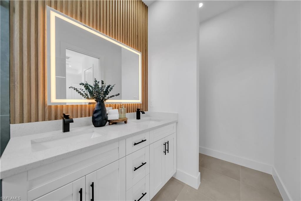 Dual vanity with white cabinetry and matte black hardware, featuring a quartz countertop and integrated rectangular sinks