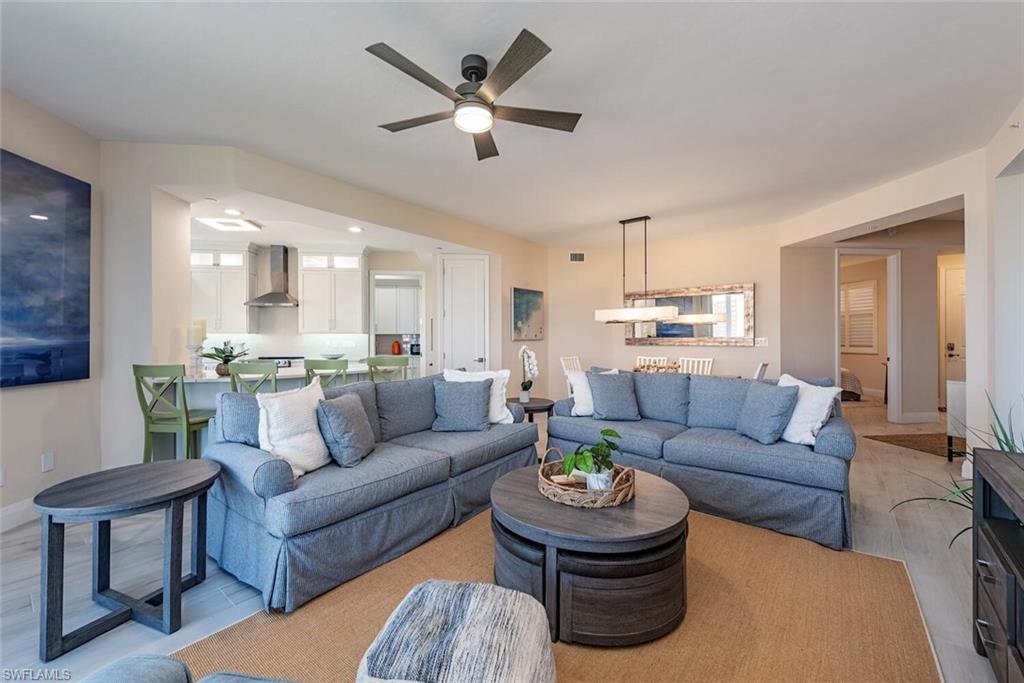 Living room featuring ceiling fan, baseboards, and light wood-style floors