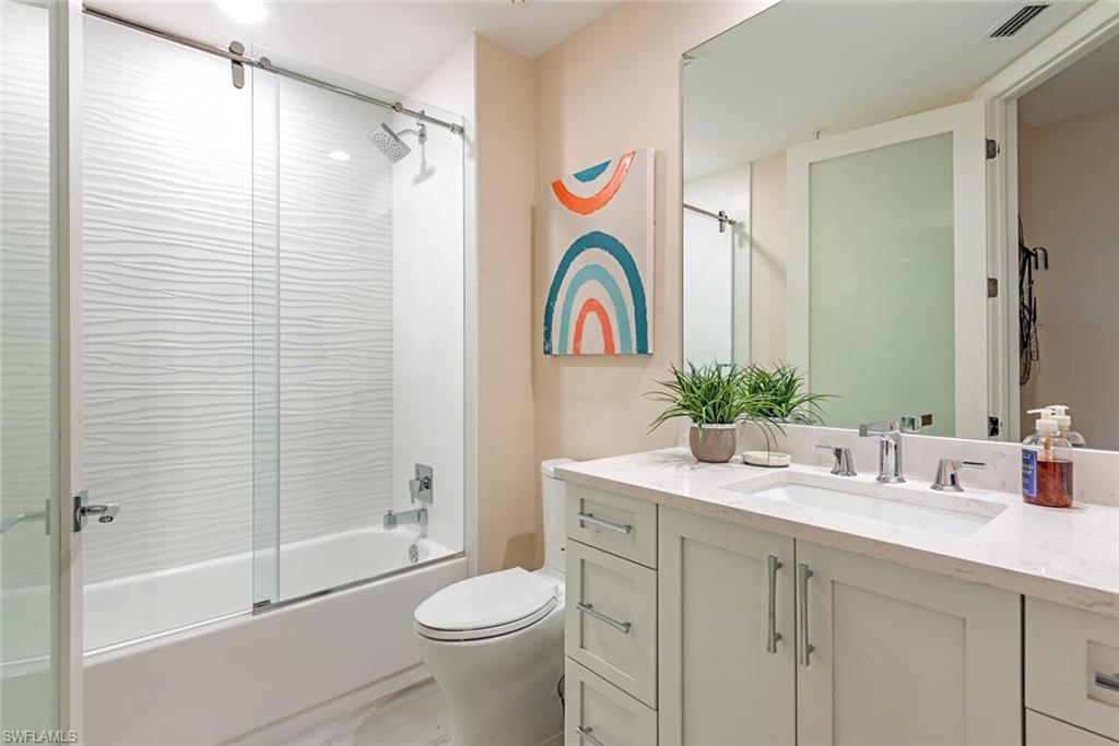 Full bath featuring vanity, toilet, and enclosed tub / shower combo