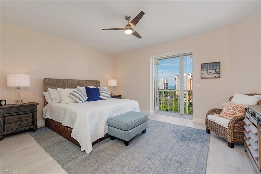 Bedroom with access to outside, ceiling fan, light wood-type flooring, baseboards, and a city view