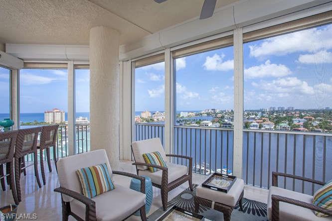 Sunroom / solarium featuring a water view, a textured ceiling, and a view of city