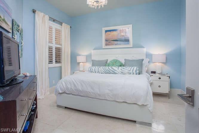 Bedroom with a chandelier and baseboards