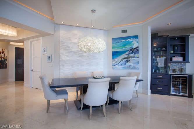 Dining room featuring beverage cooler, a chandelier, a dry bar, baseboards, and recessed lighting