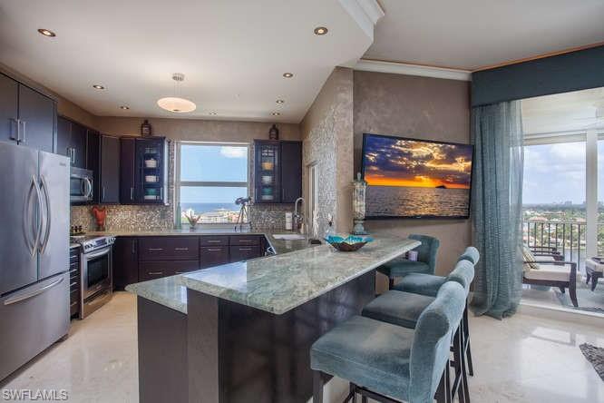 Kitchen with stainless steel appliances, a sink, a peninsula, healthy amount of natural light, and recessed lighting