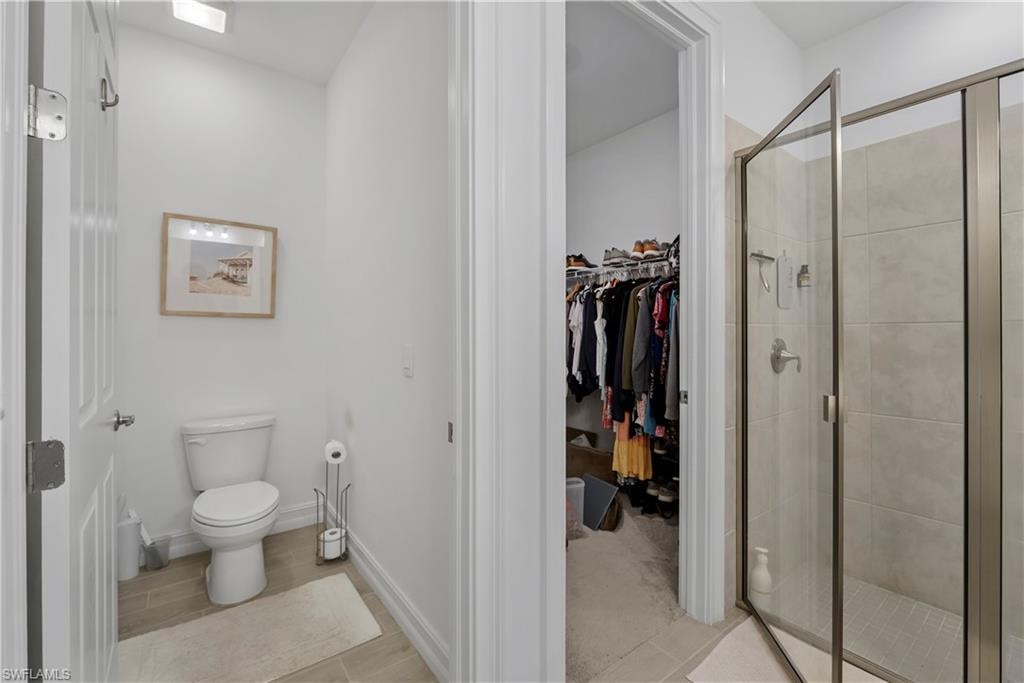 Walk-in shower with clear glass enclosure and tiled walls