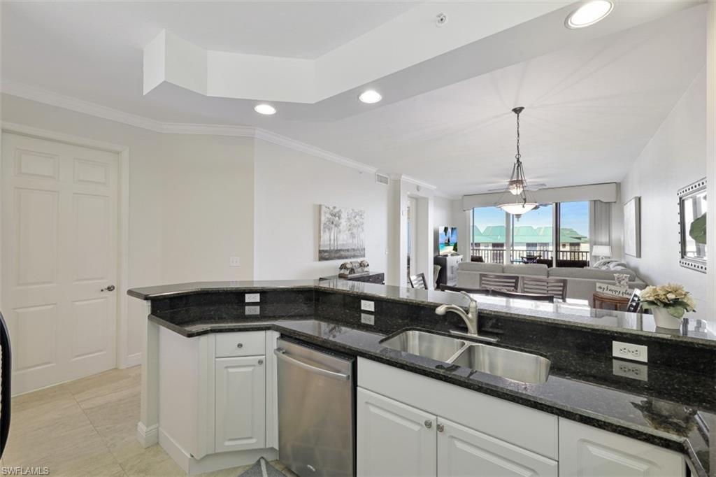Kitchen with a sink, stainless steel dishwasher, open floor plan, white cabinets, and crown molding