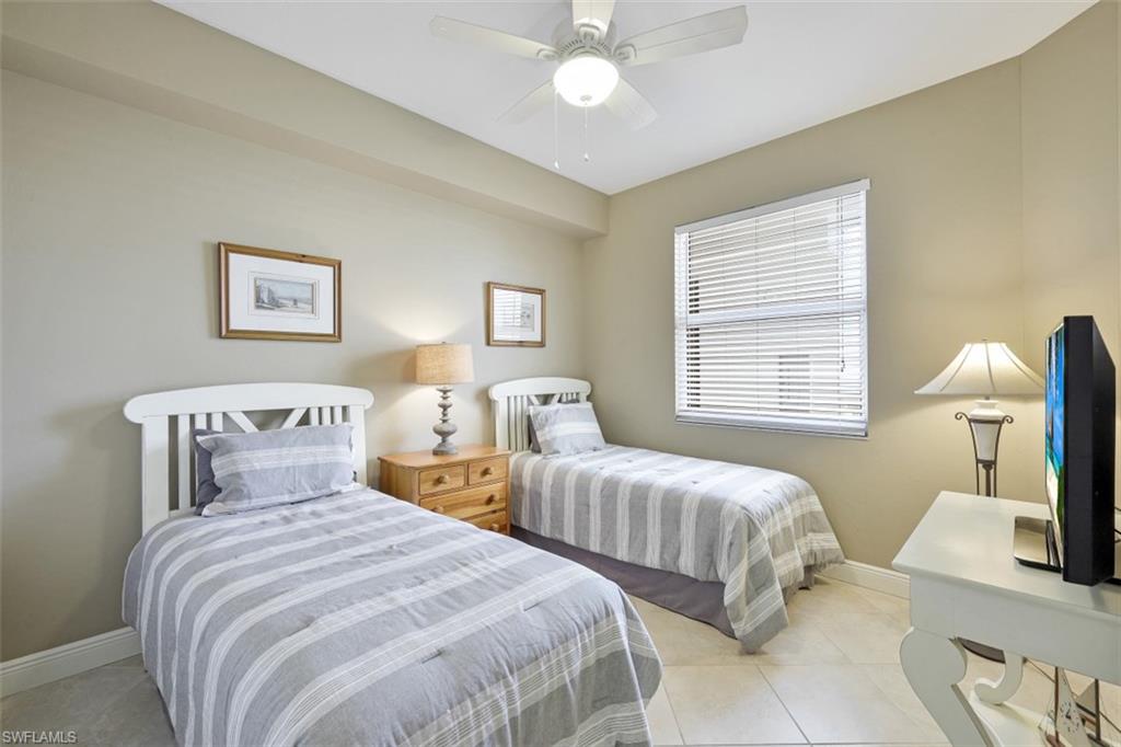 Bedroom featuring light tile patterned flooring, ceiling fan, and baseboards