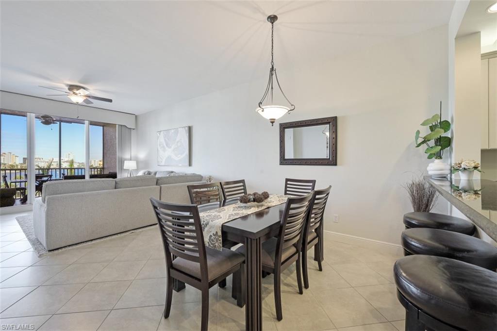 Dining room with light tile patterned floors, baseboards, and a ceiling fan