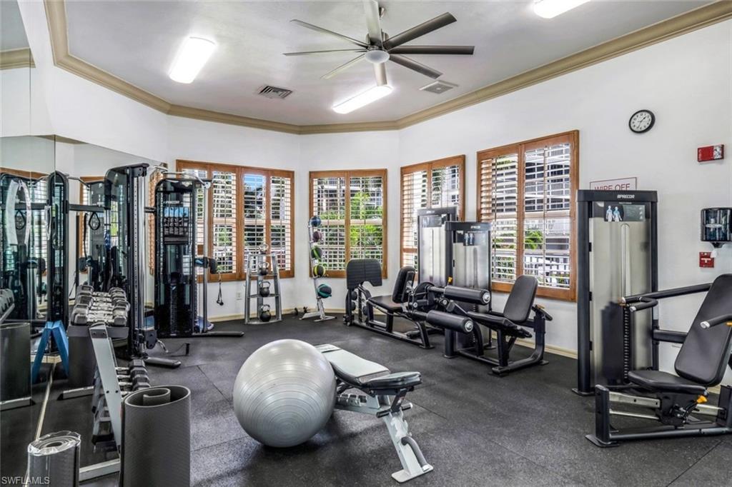 Workout area featuring a ceiling fan, ornamental molding, and baseboards