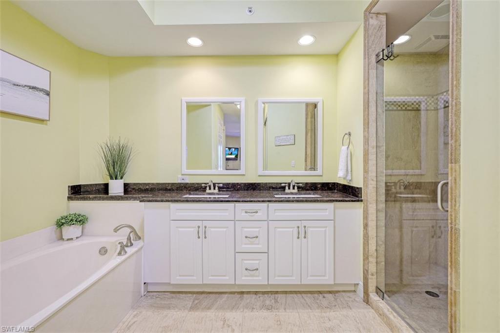 Bathroom with a bath, a stall shower, and a sink