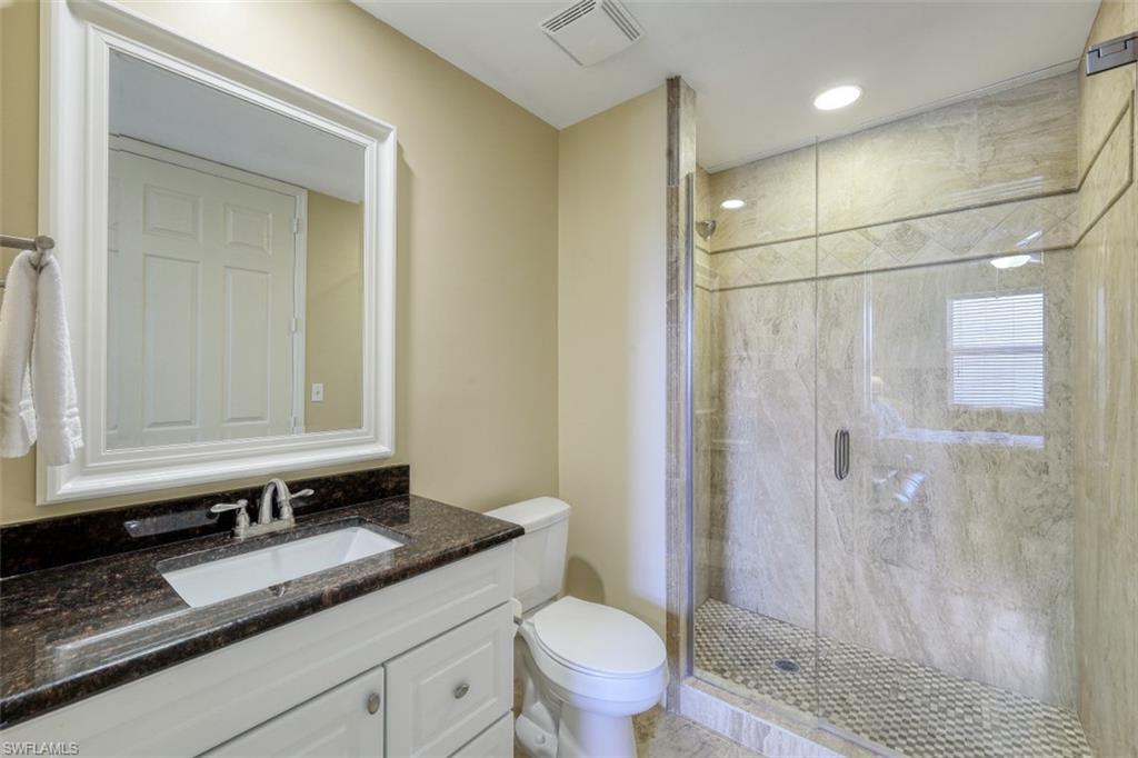 Full bathroom with visible vents, a shower stall, toilet, and vanity
