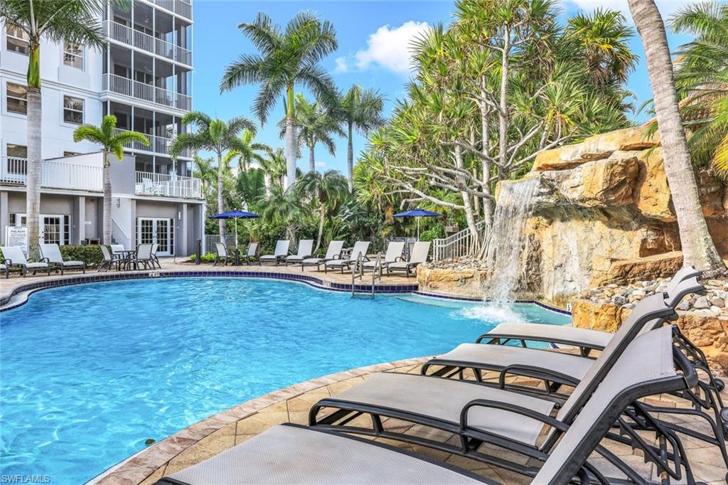Community pool with a patio area and fence