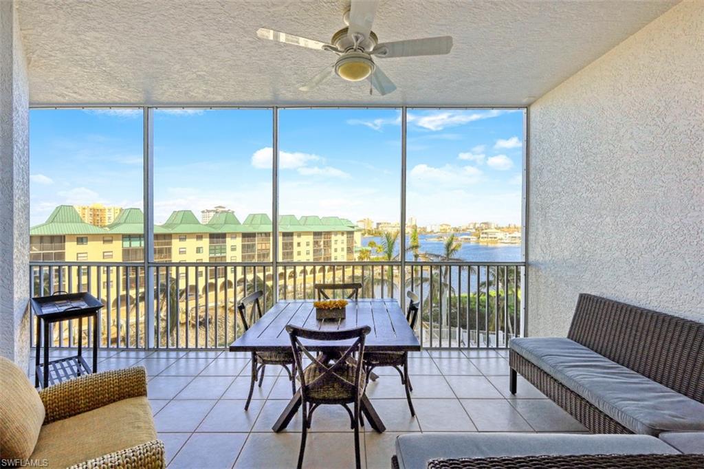 Sunroom / solarium featuring a ceiling fan and a water view