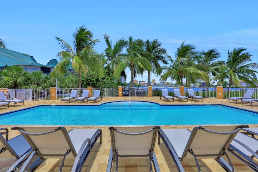 Community pool featuring fence and a patio area