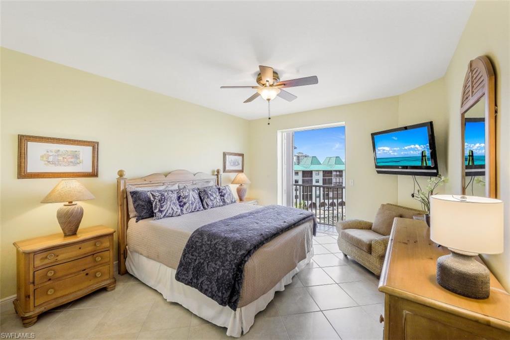 Bedroom featuring access to exterior, light tile patterned flooring, and a ceiling fan