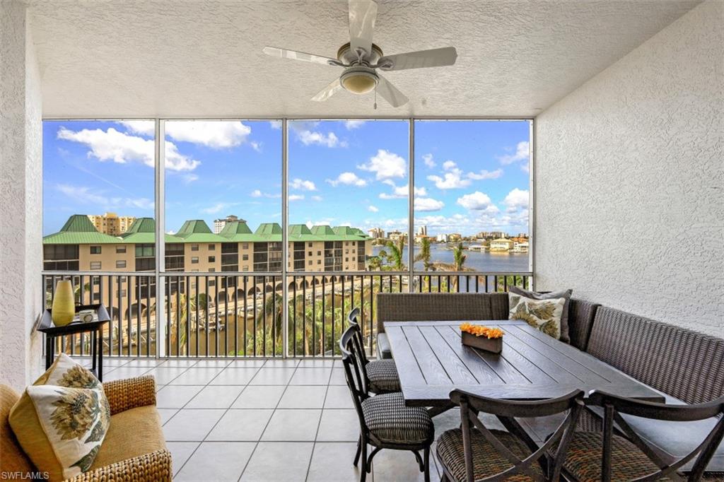 Sunroom / solarium with a water view and ceiling fan