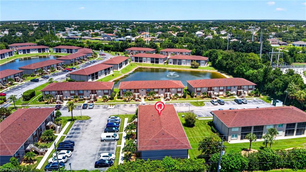 Community with multiple residential buildings, surface parking areas, and several water features