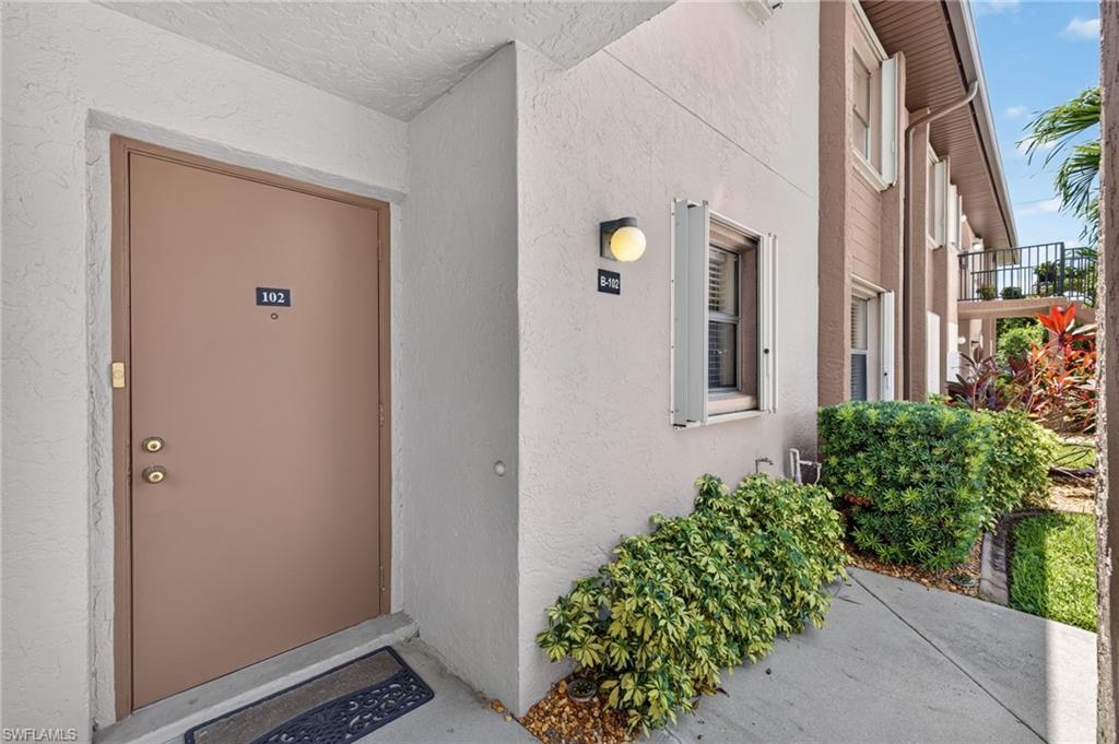 Entryway featuring a solid door, exterior wall light, and decorative window shutters
