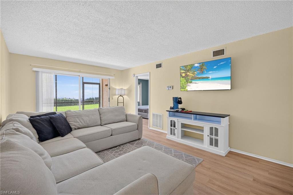 Recessed lighting, wood-finish flooring, and light-toned walls