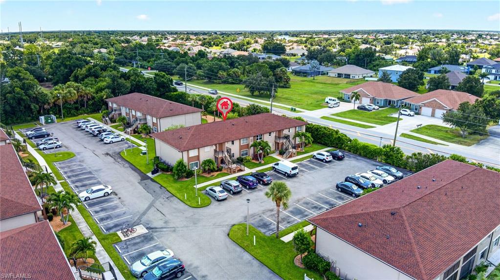 Multi-unit property with a paved parking area and mature landscaping