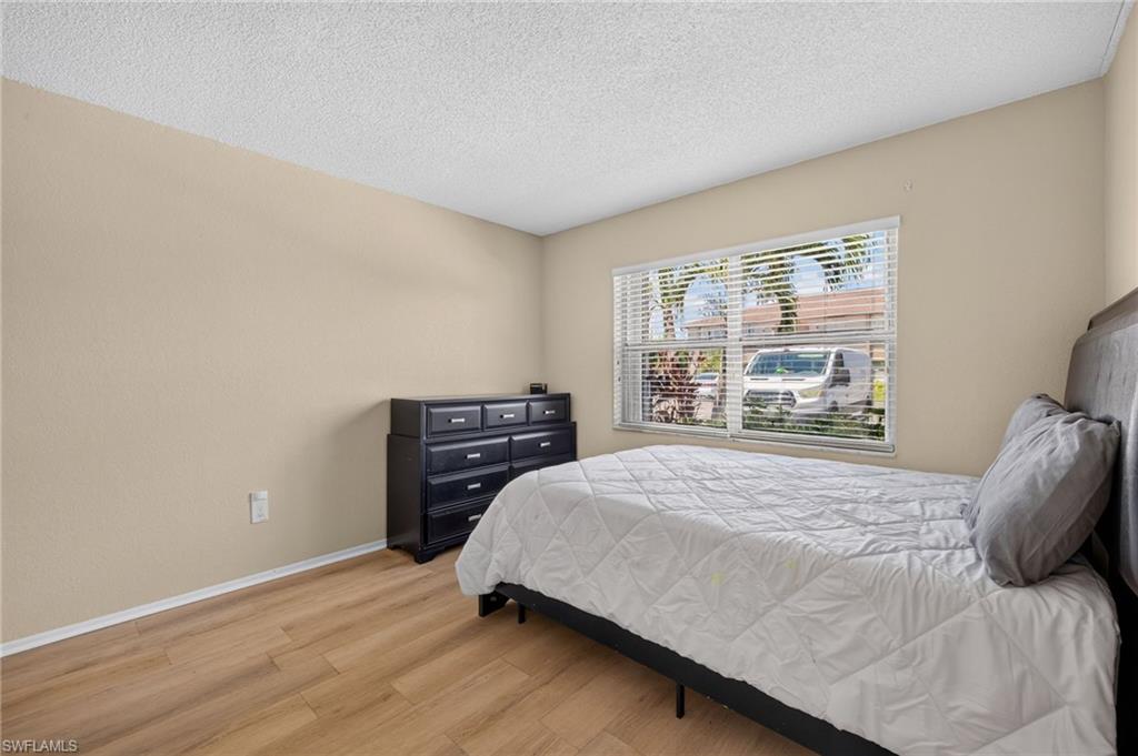 Wood-finish flooring, neutral wall tones, and horizontal blinds