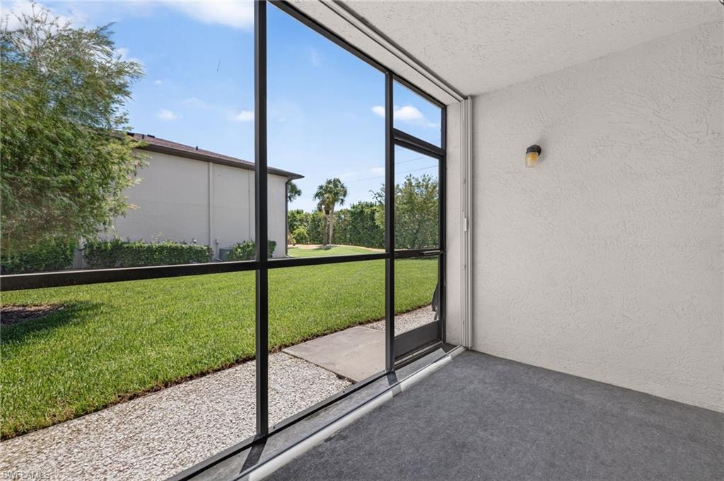 Screened patio with textured ceiling, wall-mounted light fixture, and textured wall finish