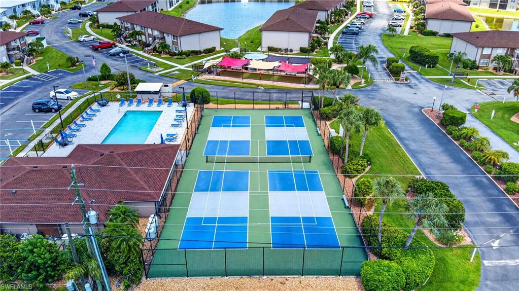 Community amenities featuring four pickleball courts, an outdoor swimming pool, and a structured clubhouse with a shingled roof