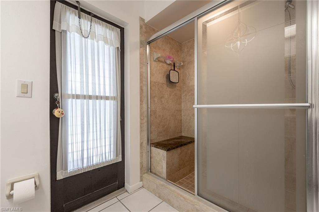POOL BATH with Tiled walk-in shower with a built-in bench, frosted glass sliding door, and decorative glass etching