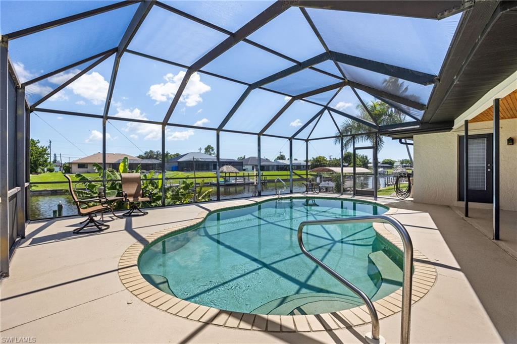 Screened enclosure featuring a contoured pool, concrete paver decking, and direct water access