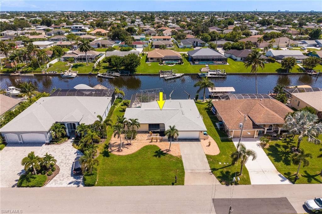 Waterfront property with canal access, private boat dock, and a screened outdoor enclosure