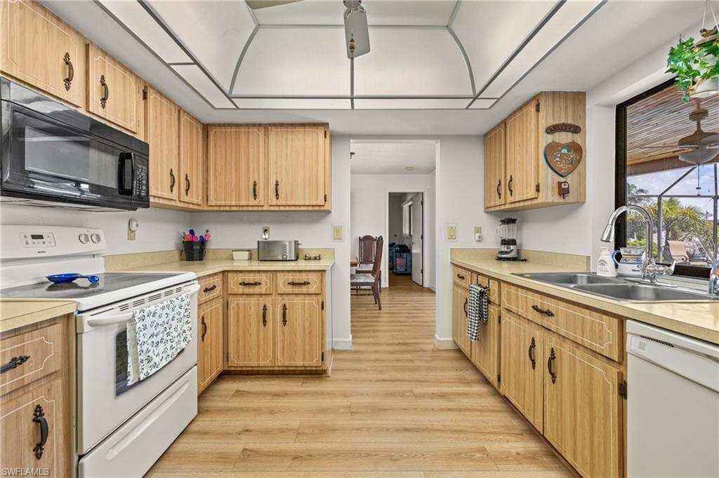 Kitchen featuring wood-finish cabinetry, light-toned countertops, and wood-finish flooring