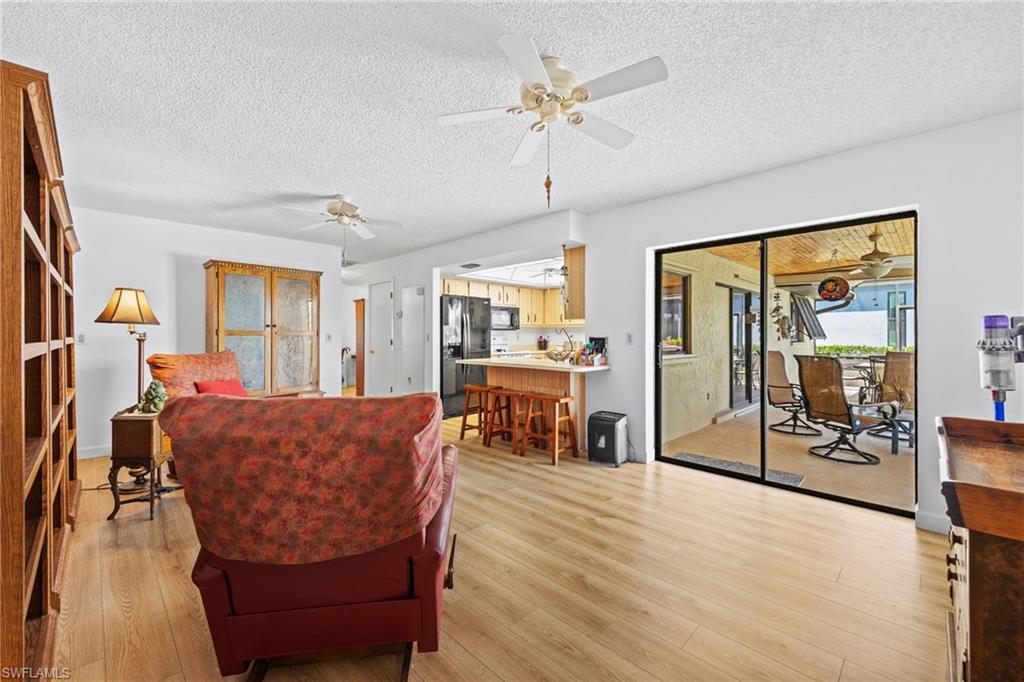 Wood-finish flooring, ceiling fans, glass sliding doors, and an outdoor patio with a ceiling fan