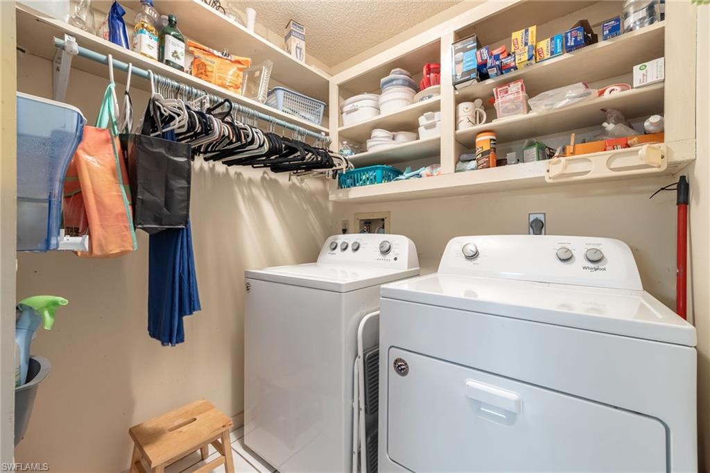 Laundry area featuring built-in shelving, a clothes hanging rod, and a washer and dryer