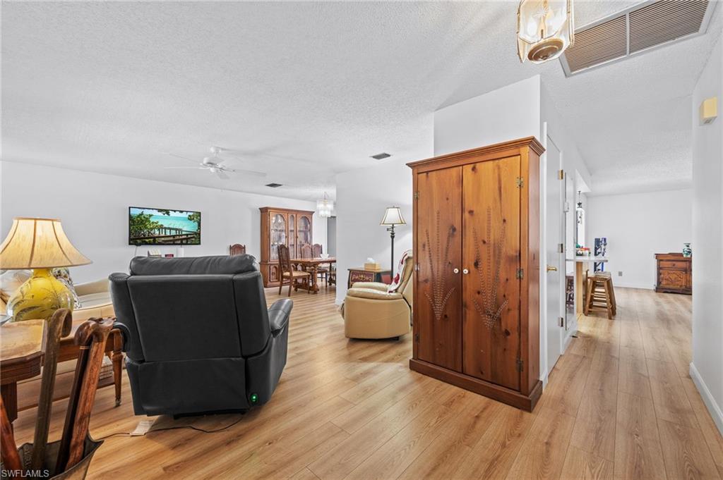 Wood-finish flooring throughout, white walls, and recessed lighting