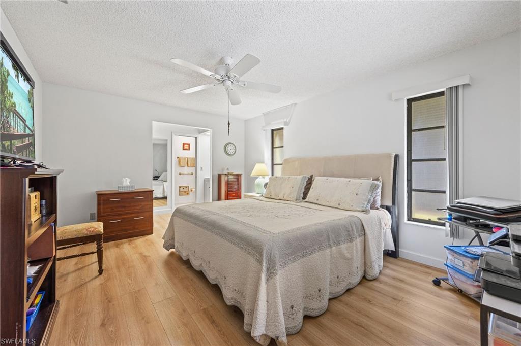 Large Owner suite has walk in closet, Wood-finish flooring with white walls and a ceiling fan
