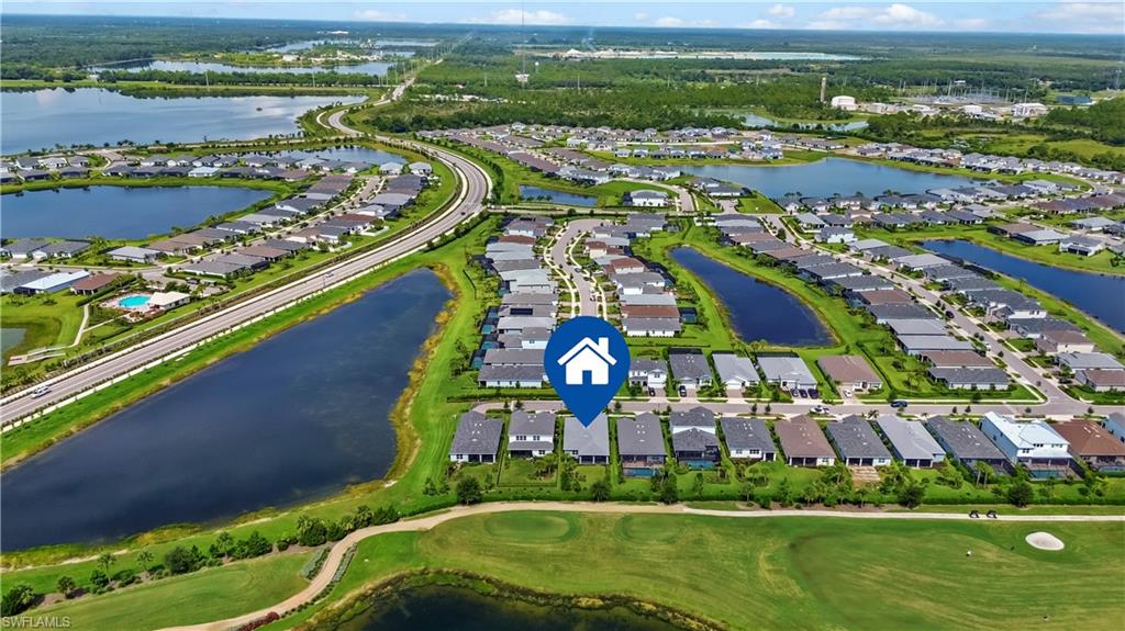 Aerial perspective showcasing a residential community with numerous water features, a golf course, and paved roads