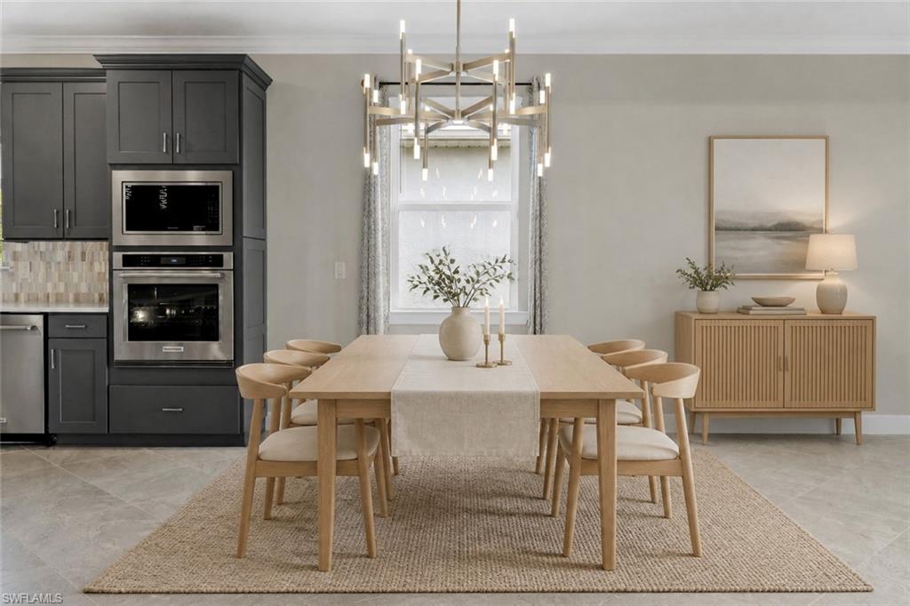 Built-in stainless steel appliances, dark gray cabinetry, light-toned wood-finish flooring, and a modern chandelier